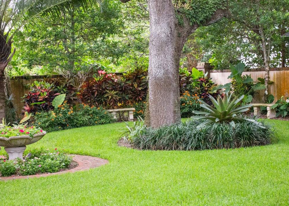 Plush grass with manicured flower beds around trees