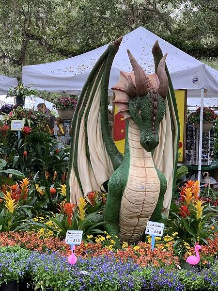 Large dragon in the middle of different color flowers