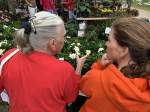 Two women looking at white flowers at gardenfest