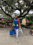 Woman in blue apron holding two bags at gardenfest